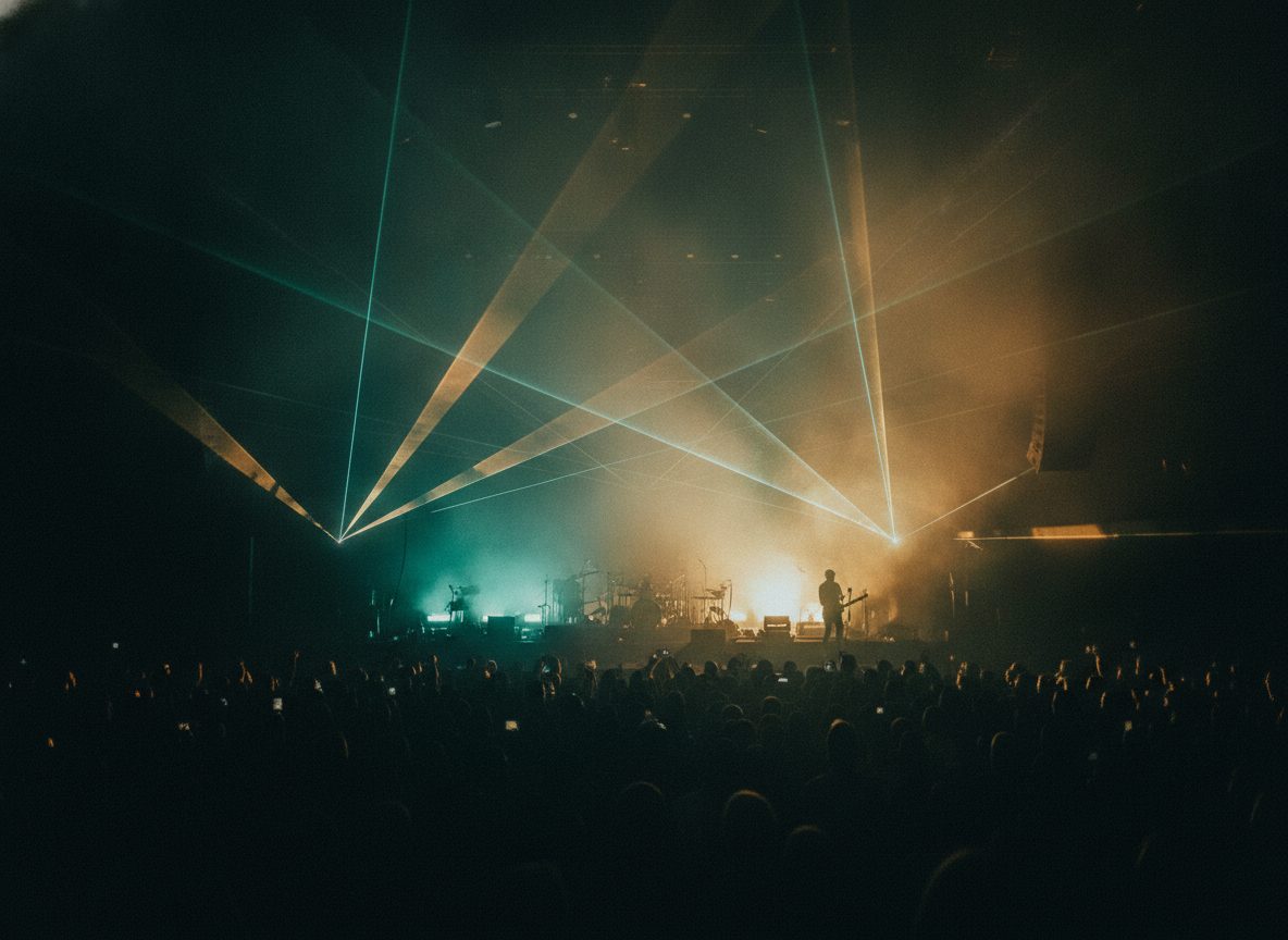 A haze of colored stage lights and lasers washing over a dark concert crowd