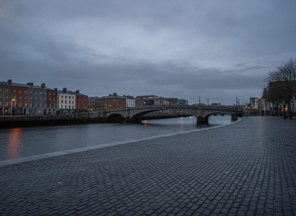 A grey Dublin river quay at dusk, wet cobblestones and a bridge under low overcast sky