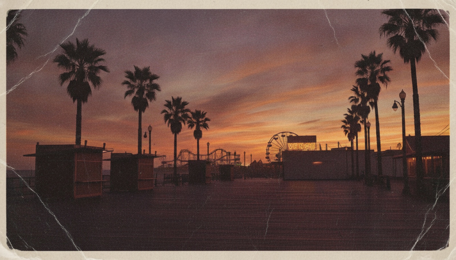 A 1960s Venice Beach boardwalk at dusk, palm trees silhouetted against a purple sky